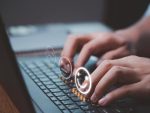Mains tapant sur un clavier d’ordinateur portable avec des icônes de satisfaction et des étoiles symbolisant l’expérience utilisateur et l’évaluation en ligne.